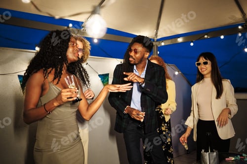 Visualização: Amigos multiétnicos curtindo uma festa na cobertura, bebendo e dançando