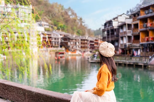 Preview: Young female tourist looking at the beautiful landscape of Feng Huang Ancient Town