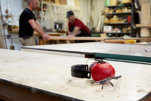 Preview: Close up of headphones and safety goggles on workshop table