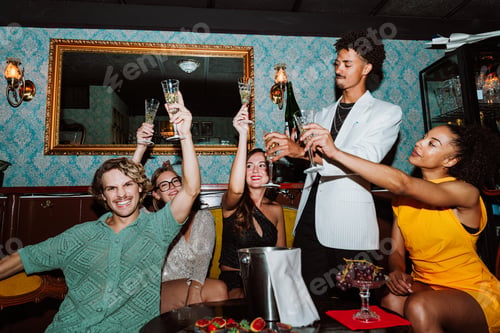 Preview: Diverse friends celebrating with champagne at a lively party
