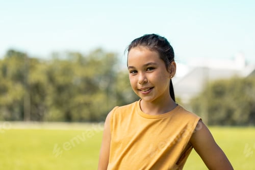 Preview: Portrait of caucasian schoolgirl smiling in sports field at elementary school