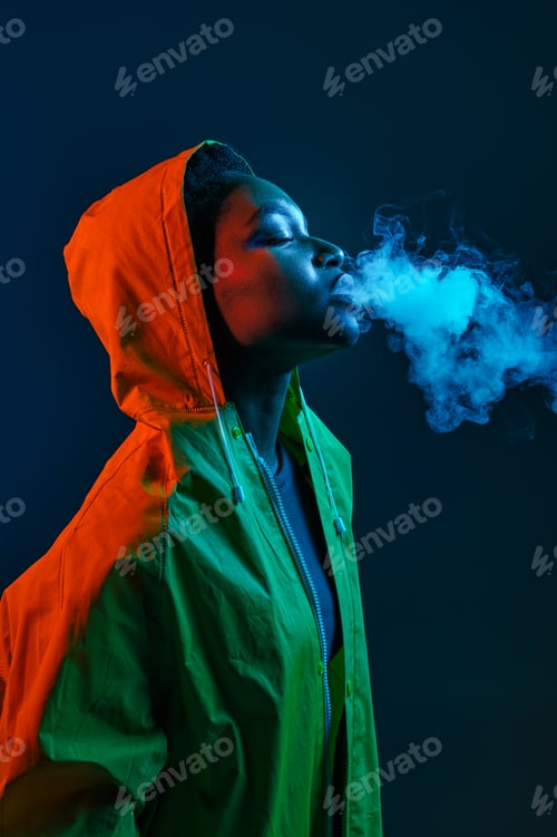 Preview: Hipster woman in raincoat blowing smoke from mouth