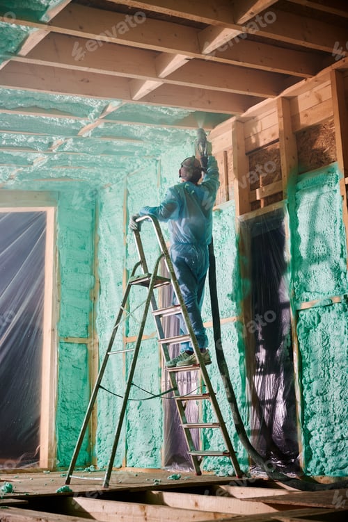 Preview: Worker spraying polyurethane foam for insulating wooden frame house.