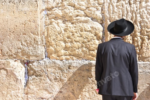 Preview: Man wearing a hat and a suit looking at the Western Wall, Jerusalem