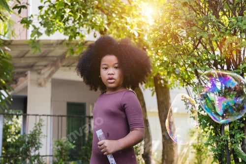 Preview: African American girl blowing big bubbles. enjoy happy time in the park. preschool kid