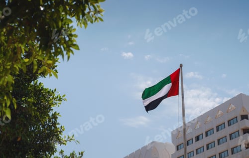 Preview: United Arab Emirates flag flying against sky.