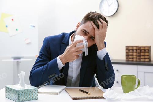Preview: Sick young man at workplace. Influenza virus