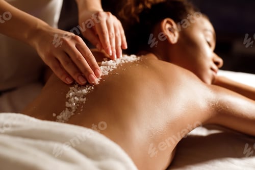 Preview: African-american woman having exfoliation treatment in spa