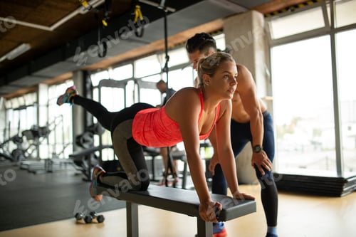 Preview: Personal trainer helping a woman to working out in gym. Sport people healthy lifestyle concept