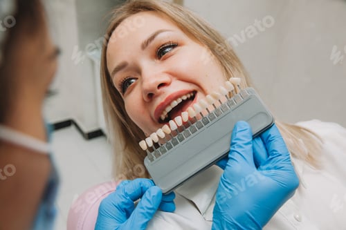 Preview: the girl in the dentist's office selects the color of the tooth enamel