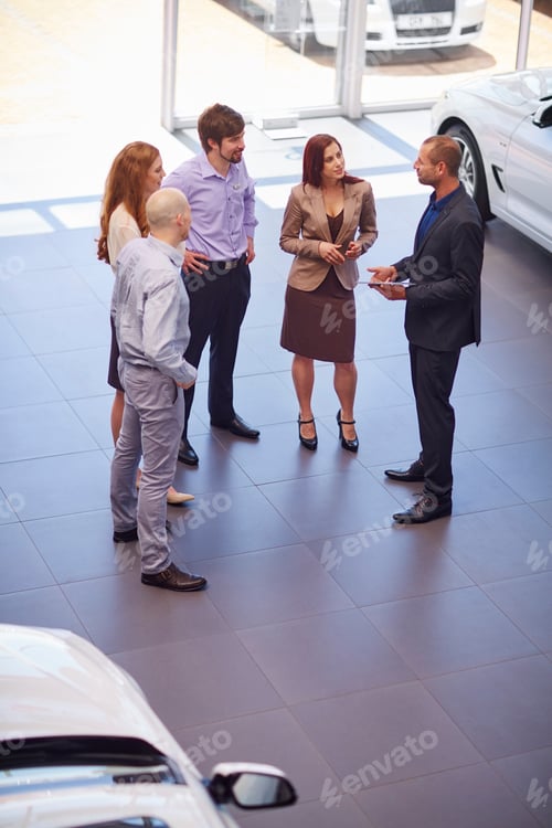 Preview: Car dealer meeting with clients in showroom