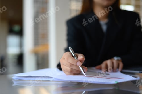 Preview: Focused on businesswoman hand writing on paper, filling paper business document at office desk