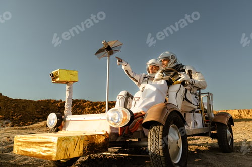 Preview: Two astronauts explore a sandy landscape in a homemade rover under a clear blue sky