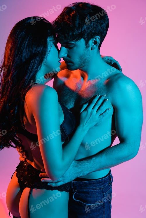 Preview: blue lighting on young and sexy couple hugging on pink