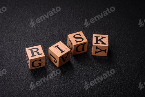 Preview: The inscription risk with wooden cubes on a dark concrete background