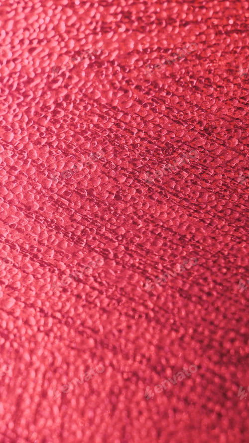 Preview: Vertical image of rain drops on a vibrant pink background illuminated under bright light