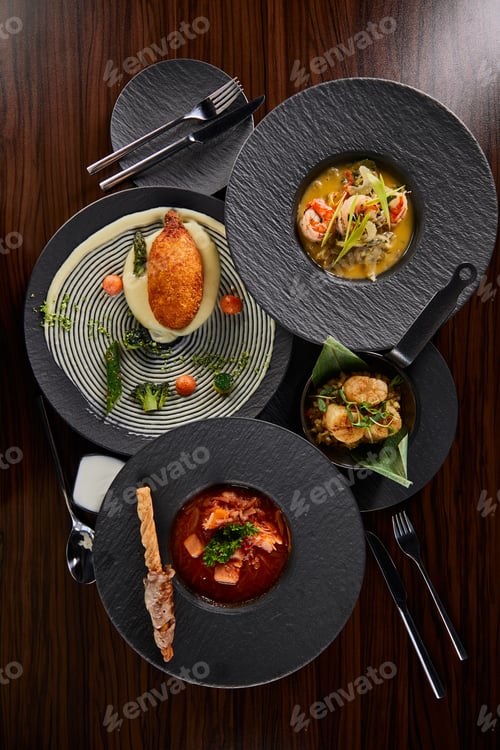 Preview: top view of delicious restaurant dishes with cutlery on wooden table