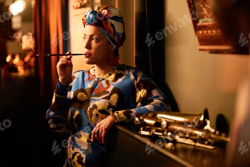 Vista previa: Multiethnic Woman in Headwrap Smoking Cigarette Listening to Jazz Music Indoors