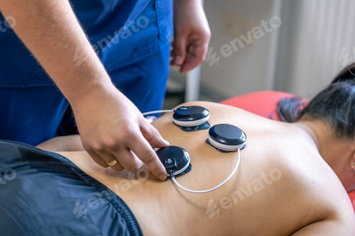 Preview: Woman receiving myostimulation treatment in physical therapy clinic.