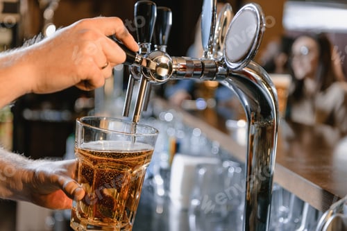 Preview: cropped image of barman pouring beer in glass at bar