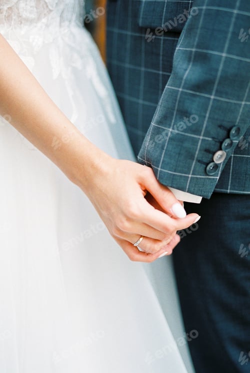 Preview: Bride holds groom hand. Close-up