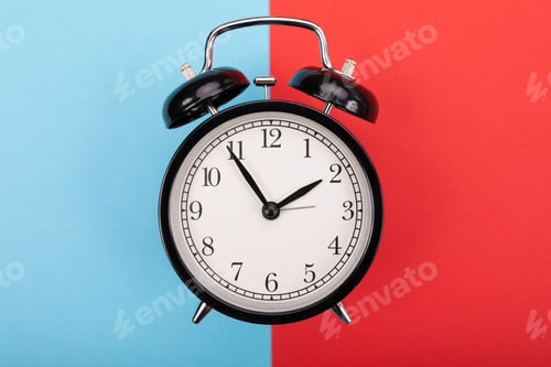 Preview: black metal arrow alarm clock on blue-red background