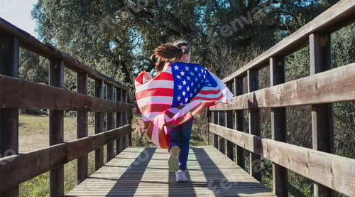 Preview: Young girl running on wooden bridge with usa flag