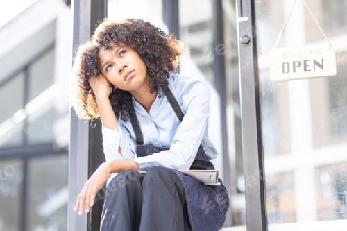 Preview: Portrait of Young african american small business owner woman wearing apron and looking away to you
