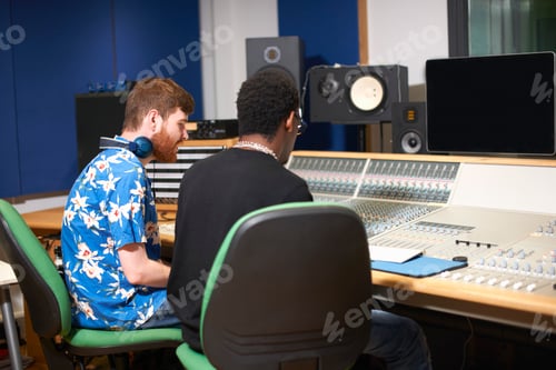 Preview: Two young male college students at sound mixer in recording studio