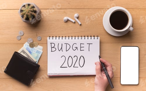 Preview: Woman hand writing new year budget on notepad