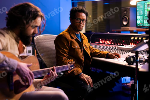Preview: Singer recording electro acoustic guitar in professional music studio
