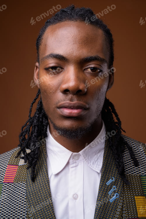 Preview: Young handsome African businessman against brown background