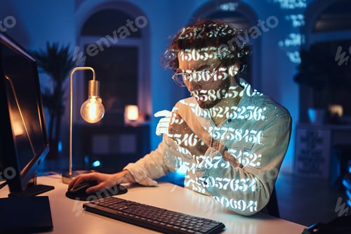 Preview: Caucasian freelancer with glasses and computer works in dark office