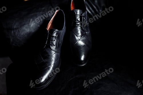 Preview: men's shoes on a dark background. Stylish men's shoes on a table on a dark wooden background