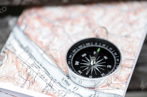 Preview: Compass and map on a beautiful wooden surface. Top view