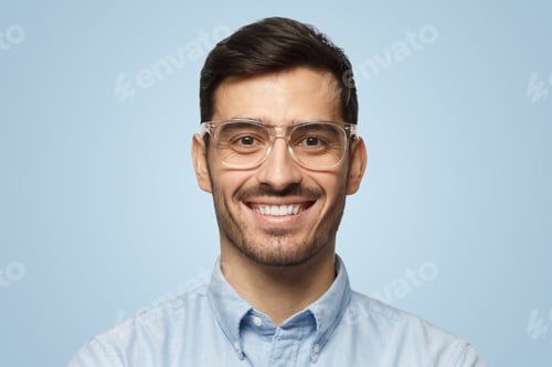 Preview: Smart businessman smiling at camera, in transparent glasses, isolated on blue background