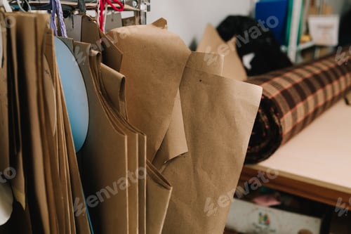 Preview: Garment sewing patterns hang on a metal rack inside a clothing production studio. .