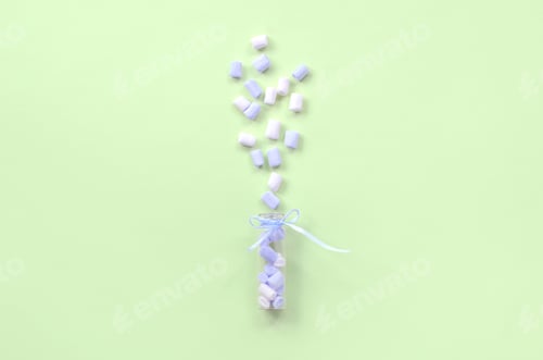 Preview: Marshmallow is sprayed from a small glass container on a lime background.