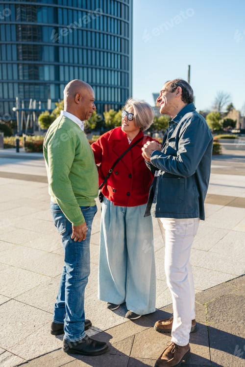 Preview: Three mature friends enjoying a conversation outdoors