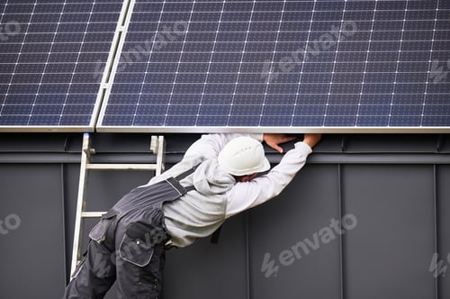 Preview: Electricians connecting cables while installing photovoltaic solar panels on roof of house.