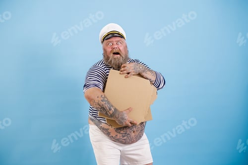 Preview: Happy bearded obese man sailor holds blank boxes of pizza posing on light blue background