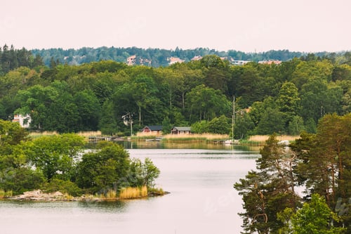 Preview: Sweden. Beautiful Swedish Wooden Log Cabins Houses On Coast In Summer Day. Lake Or River Landscape
