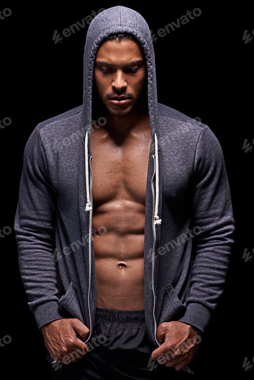 Preview: Getting his fitness on. Studio shot of a muscular young man wearing a hoodie isolated on black.