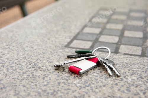 Preview: Keys forgotten on grey stone table outdoors. Space for text. Lost and found