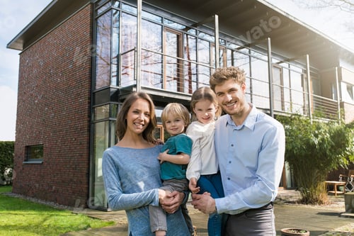Preview: Portrait of smiling family in front of their home