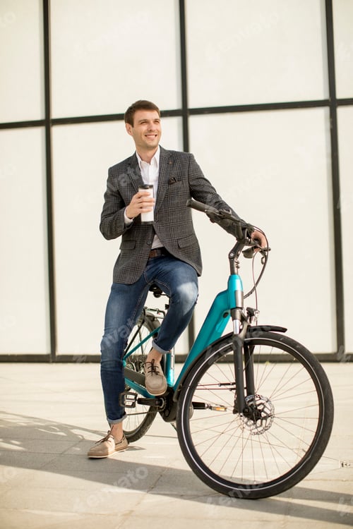 Preview: Young businessman on the ebike with takeaway coffee cup