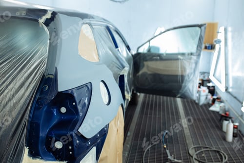 Preview: automobile repairman painter hand in protective glove with airbrush pulverizer painting car body in