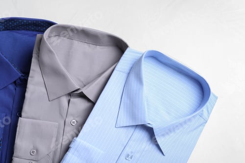 Preview: Stylish shirts on light table, flat lay. Dry-cleaning service