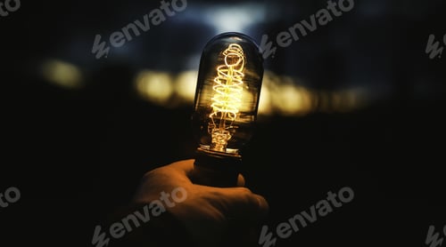 Preview: Closeup shot of a human hand holding a lamp on blurred background