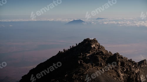 Preview: Hikers climbing mount meru in tanzania, africa, with kilimanjaro in background